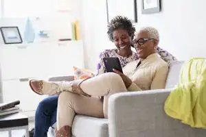 Lesbian POC couple at home looking over their retirement plan.